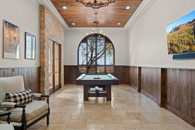 game room with a notable chandelier, crown molding, wooden walls, and wooden ceiling