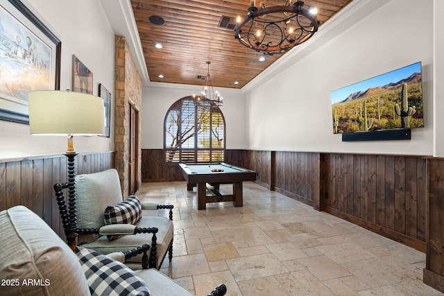 hallway featuring ornamental molding, a chandelier, wood ceiling, and wood walls