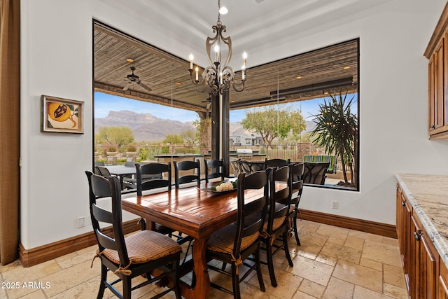 dining area featuring a mountain view and ceiling fan with notable chandelier