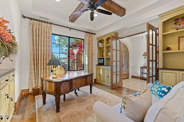 office area featuring french doors, ceiling fan, beam ceiling, and light hardwood / wood-style flooring