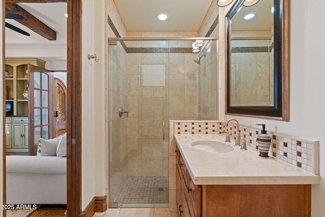 bathroom featuring walk in shower, vanity, and decorative backsplash