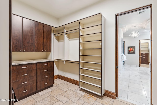 spacious closet with an inviting chandelier