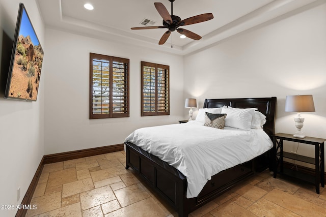 bedroom featuring a raised ceiling and ceiling fan