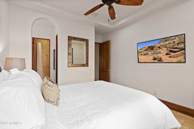 bedroom with ceiling fan and a raised ceiling