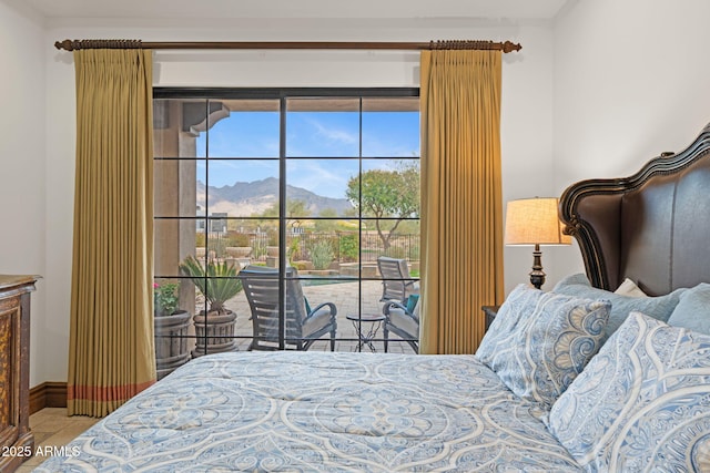 bedroom featuring access to exterior, a mountain view, and tile patterned flooring