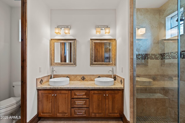 bathroom featuring vanity, a shower with door, and toilet