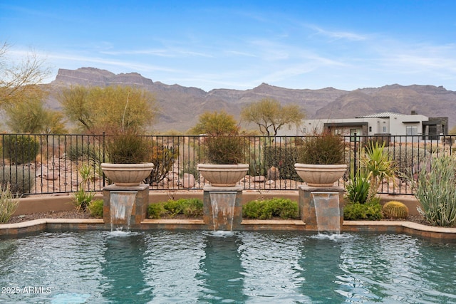 view of swimming pool with a mountain view and pool water feature