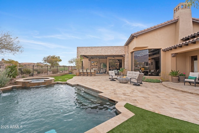 view of swimming pool featuring an in ground hot tub, an outdoor living space with a fire pit, a patio area, and a bar