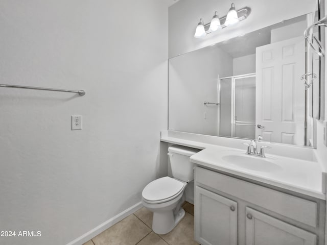 bathroom with tile patterned flooring, walk in shower, vanity, and toilet