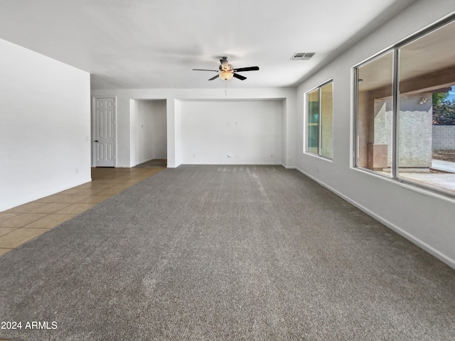 unfurnished room featuring ceiling fan and dark tile patterned flooring