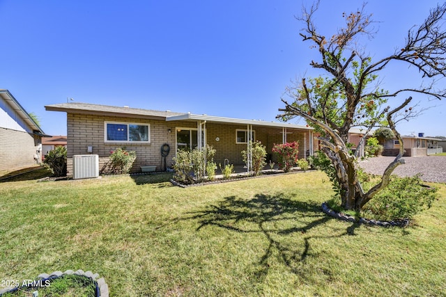 ranch-style house featuring cooling unit and a front yard