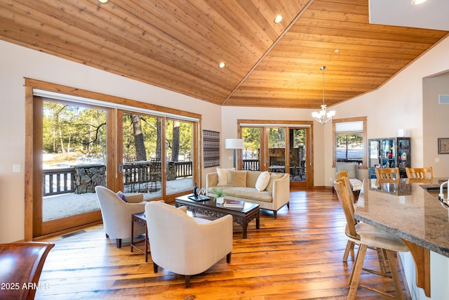 living room with a notable chandelier, plenty of natural light, and wood ceiling