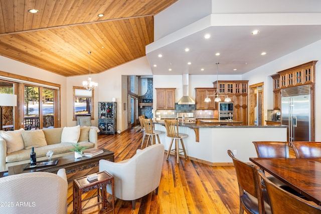 living room featuring hardwood / wood-style floors, lofted ceiling, recessed lighting, wooden ceiling, and a chandelier