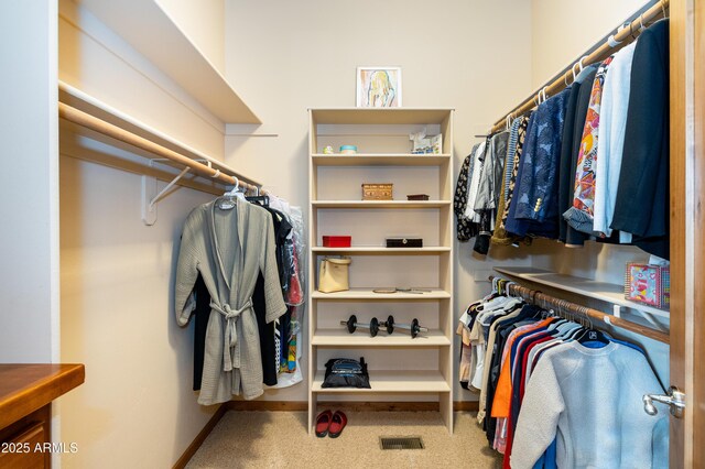 walk in closet with visible vents and carpet