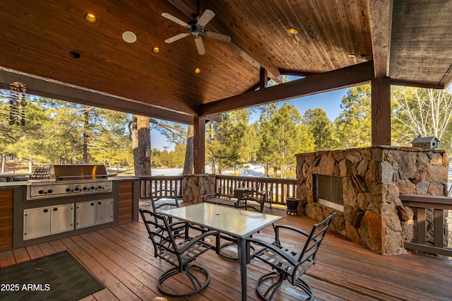 wooden deck with an outdoor kitchen, a grill, and ceiling fan