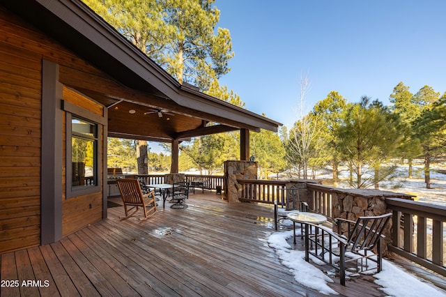 wooden terrace with outdoor dining space and ceiling fan