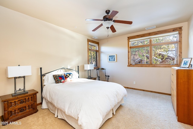 bedroom with a ceiling fan, light colored carpet, visible vents, and baseboards