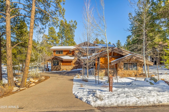 chalet / cabin with stone siding and driveway