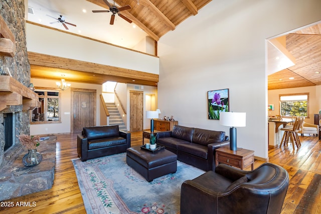 living area with wooden ceiling, hardwood / wood-style flooring, stairway, and high vaulted ceiling