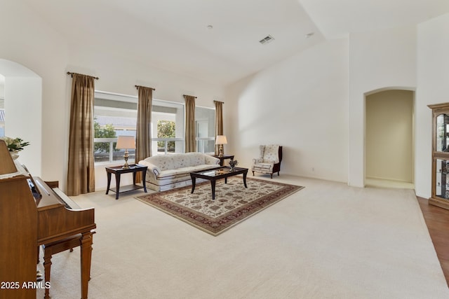 carpeted living room featuring high vaulted ceiling