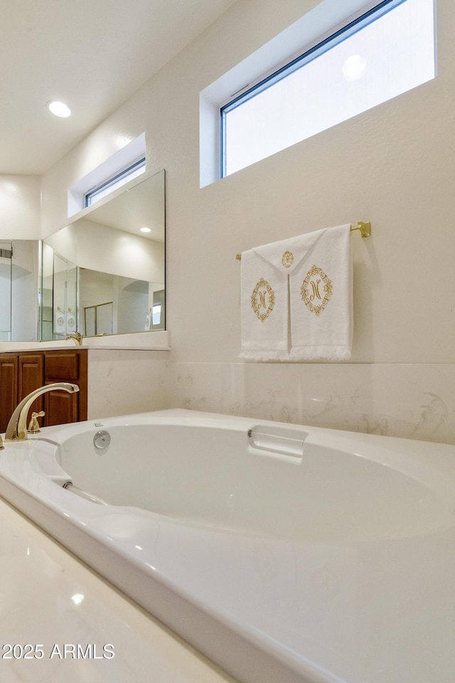 bathroom featuring a tub to relax in and vanity