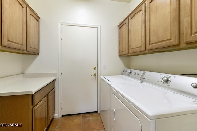 clothes washing area featuring washer and dryer, cabinets, and light tile patterned floors