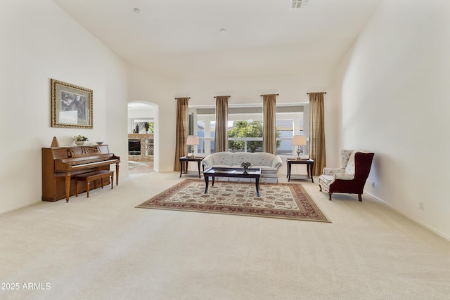 living room with light colored carpet and a towering ceiling