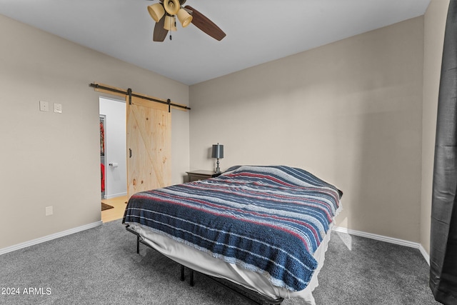 bedroom with carpet, a barn door, and ceiling fan