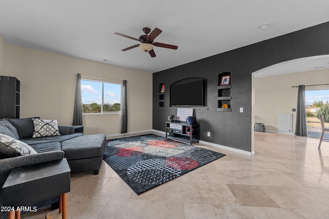 living room featuring ceiling fan and a wealth of natural light