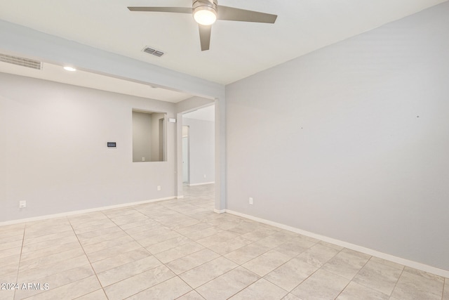 tiled spare room featuring ceiling fan