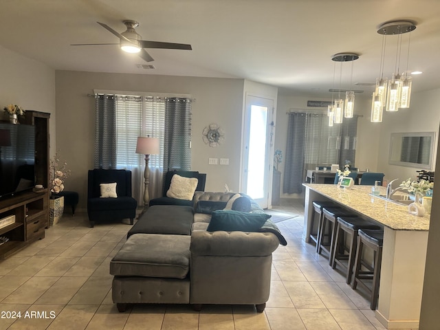 living room with ceiling fan with notable chandelier and light tile patterned floors