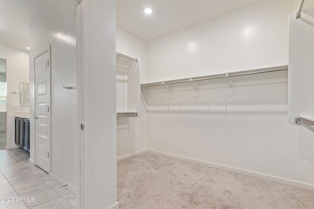 walk in closet with light colored carpet