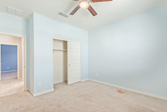 unfurnished bedroom with a closet, ceiling fan, and light carpet