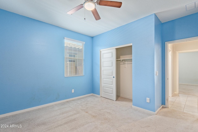 unfurnished bedroom with light carpet, ceiling fan, and a closet