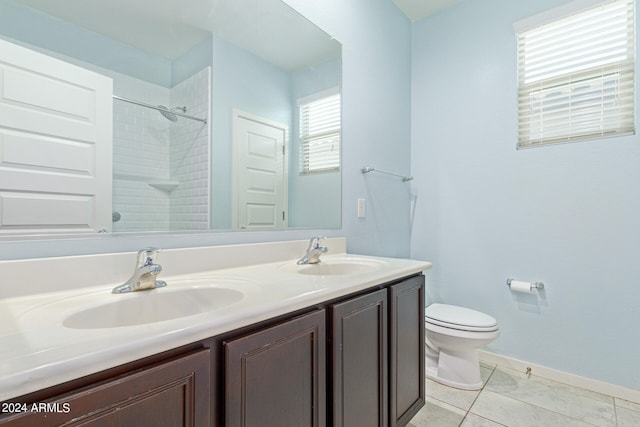 bathroom featuring vanity, toilet, tiled shower, and tile patterned floors