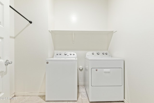 washroom with washing machine and dryer and light tile patterned floors