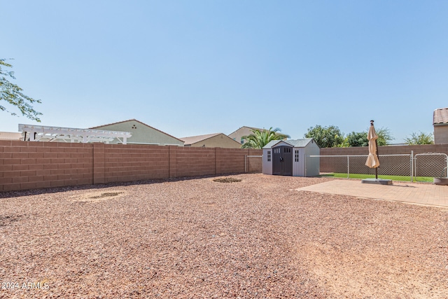 view of yard with a shed and a patio area