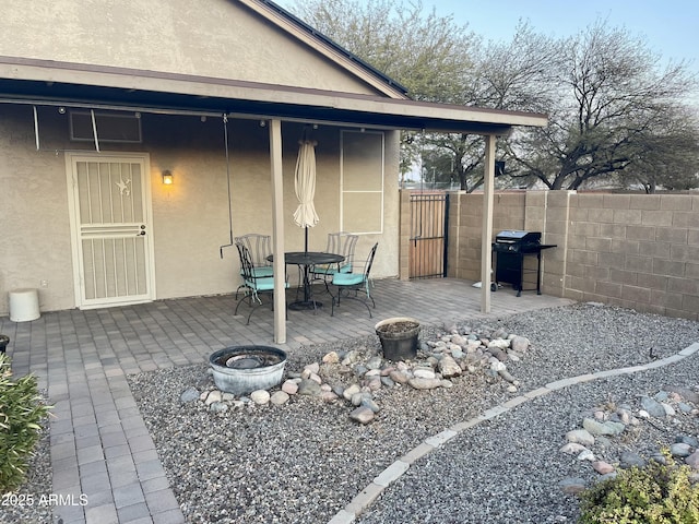 view of patio with an outdoor fire pit, outdoor dining area, fence, and grilling area