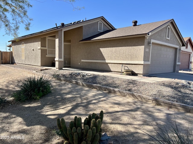 view of property exterior featuring an attached garage, driveway, fence, and stucco siding