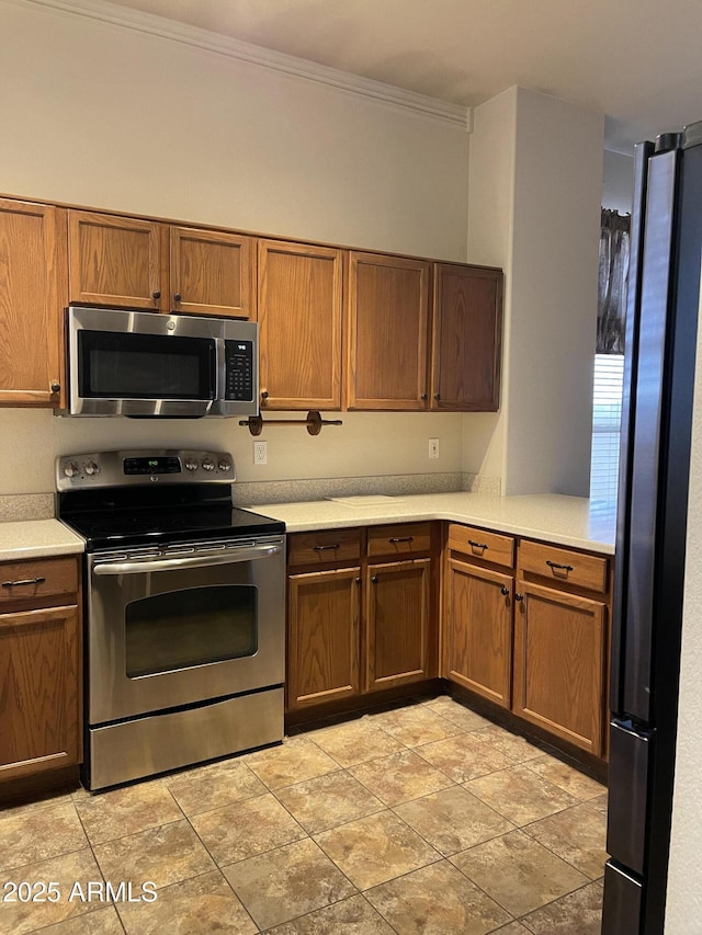 kitchen featuring stainless steel appliances, brown cabinetry, light countertops, and ornamental molding