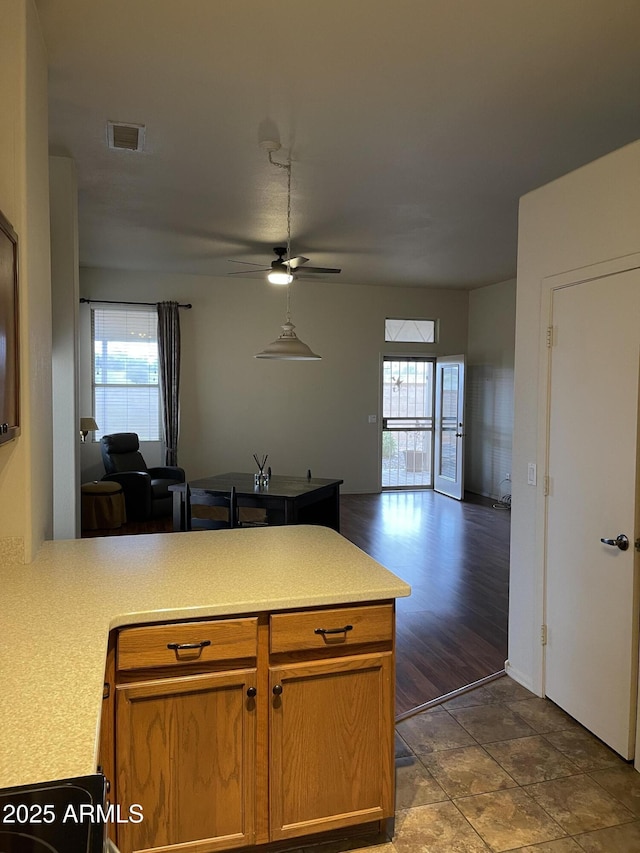 kitchen with open floor plan, a peninsula, plenty of natural light, and visible vents