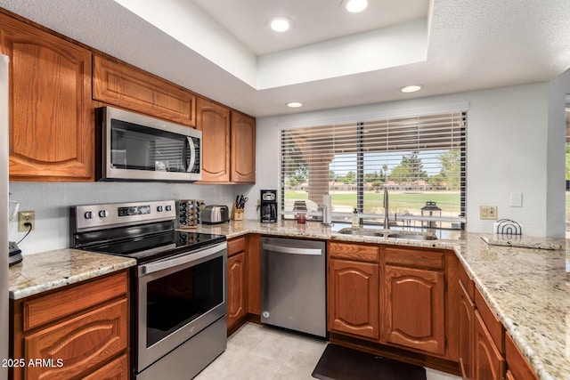9243 W Kimberly Way, Peoria, AZ 85382 - kitchen with brown cabinetry, appliances with stainless steel finishes, light stone countertops, a sink, and recessed lighting