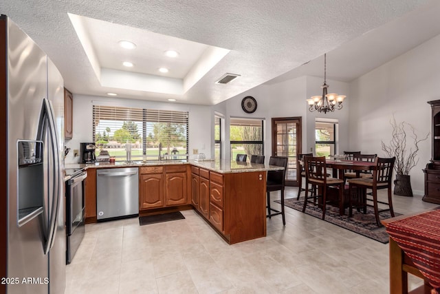 9243 W Kimberly Way, Peoria, AZ 85382 - kitchen featuring visible vents, appliances with stainless steel finishes, a peninsula, a chandelier, and a breakfast bar