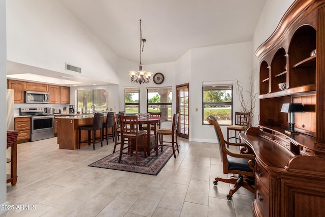 9243 W Kimberly Way, Peoria, AZ 85382 - dining area with light tile patterned floors, high vaulted ceiling, a chandelier, and visible vents