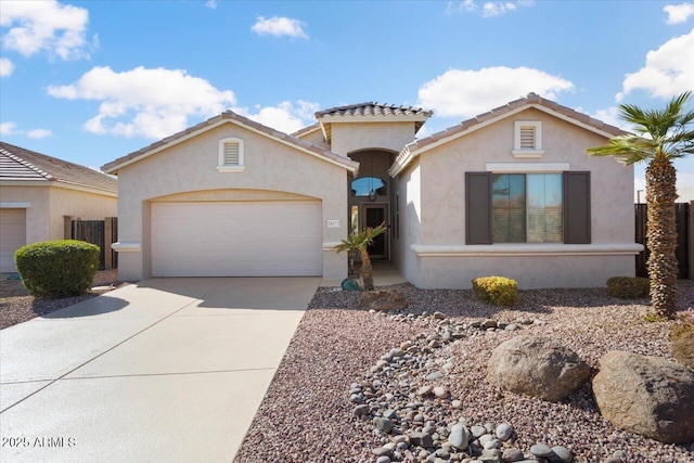 mediterranean / spanish-style house with driveway, an attached garage, a tiled roof, and stucco siding