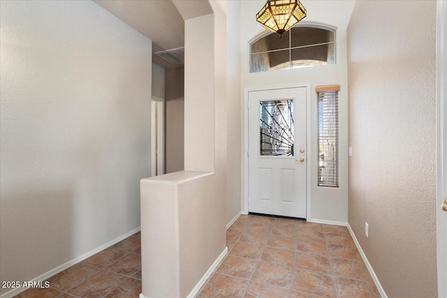 foyer entrance featuring baseboards and light tile patterned flooring