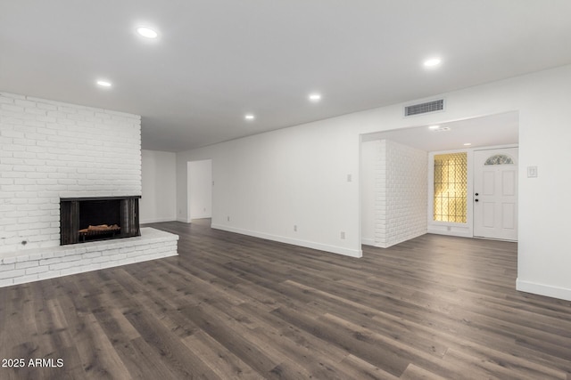 unfurnished living room featuring a fireplace and dark hardwood / wood-style floors