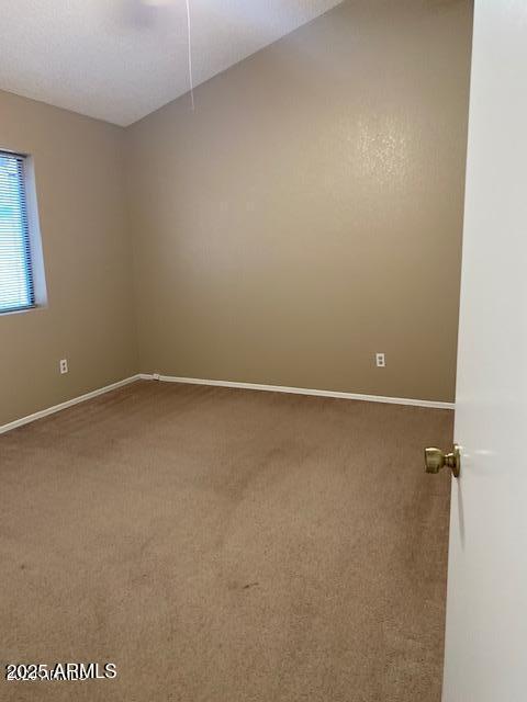 carpeted spare room featuring baseboards