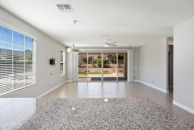 20644 W Mariposa St, Buckeye, AZ 85396 - empty room with healthy amount of natural light, tile patterned floors, a ceiling fan, and baseboards
