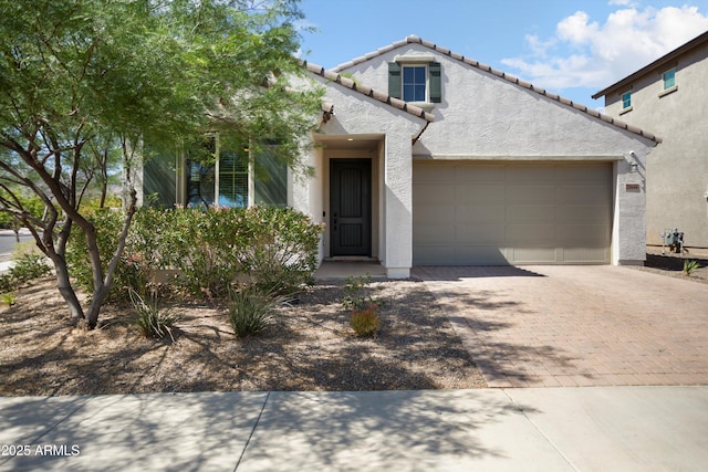20644 W Mariposa St, Buckeye, AZ 85396 - view of front of house with stucco siding, decorative driveway, an attached garage, and a tiled roof